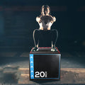 Person performing a box jump on a 20-inch box in a gym setting