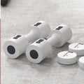 Set of white dumbbells with black circular ends on a gray surface