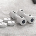 Set of white dumbbells with black weight plates on a gray surface